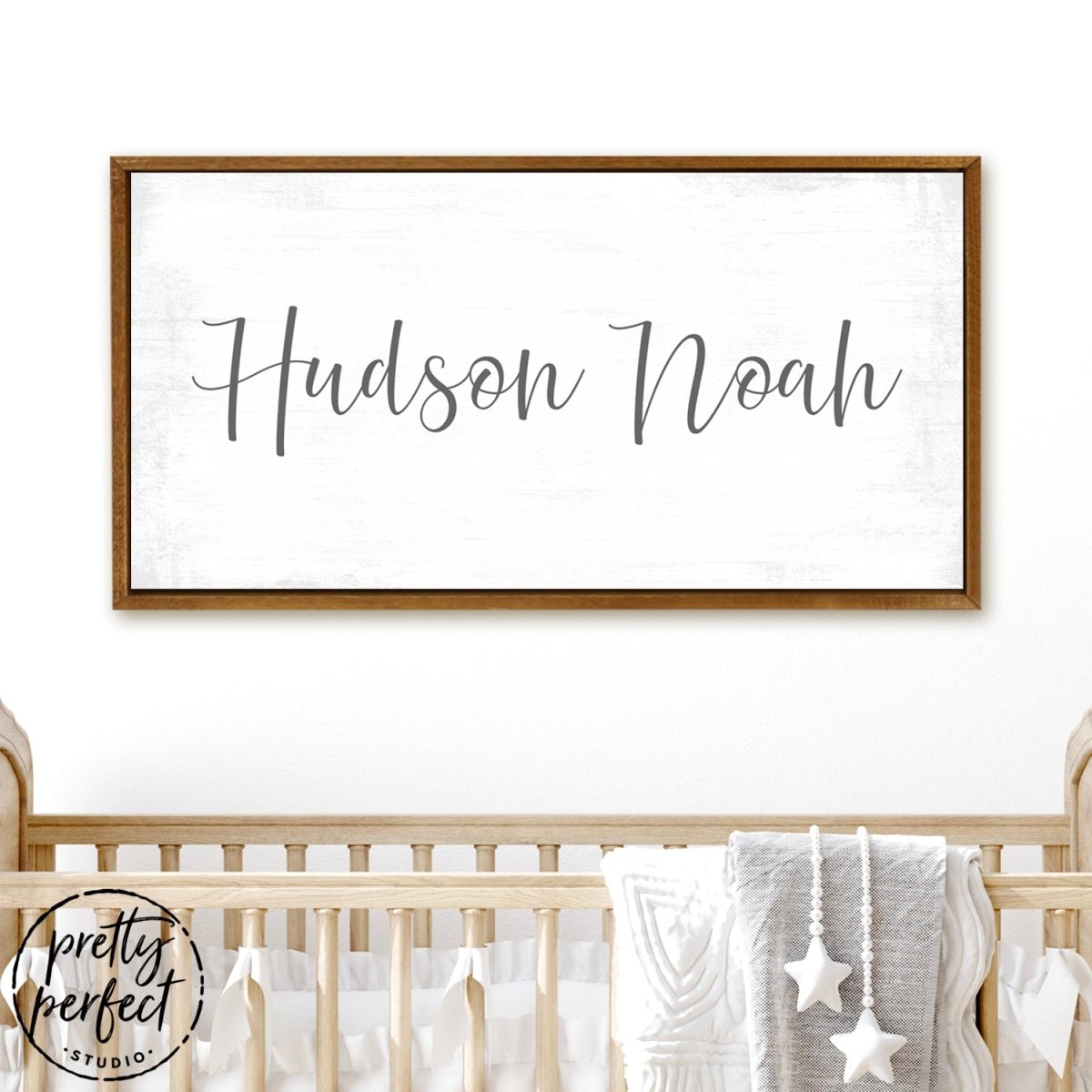 personalized baby boy name sign with minimalist script font on distressed white background in teak frame for nursery wall decor