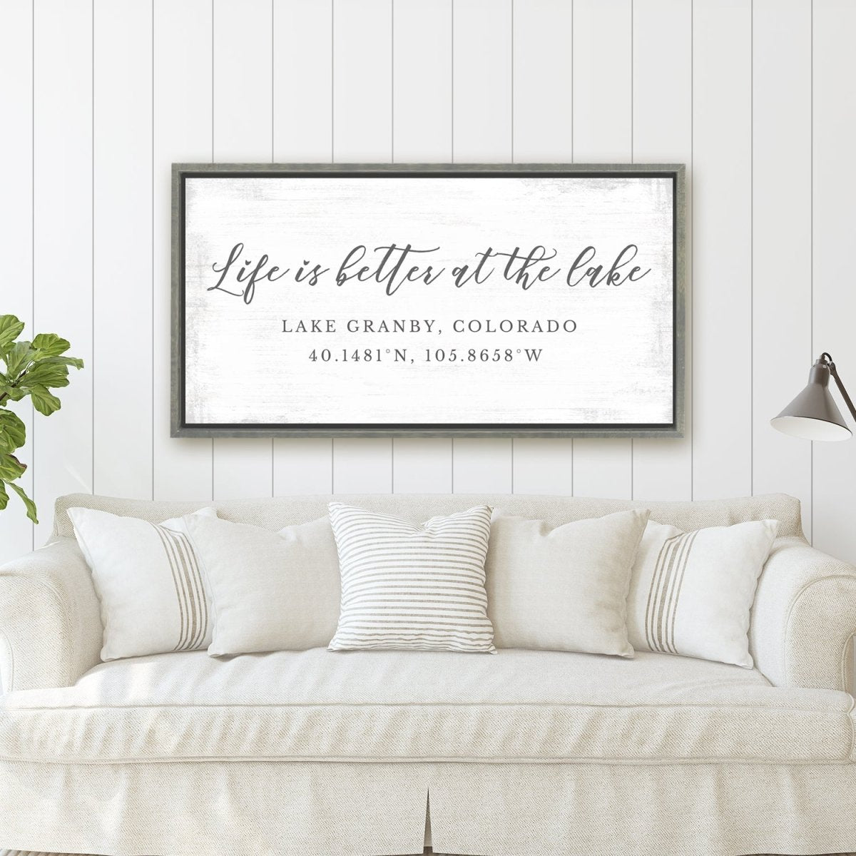 Personalized lake sign above a white sofa in a clean, minimalist home interior