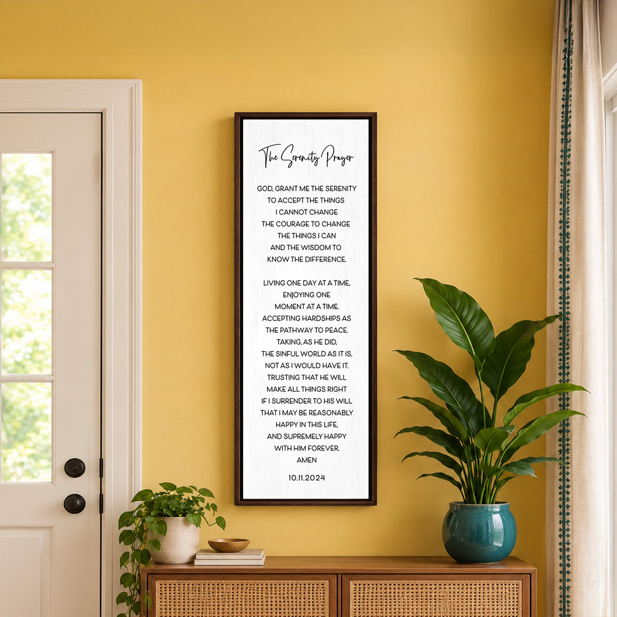Personalized Serenity Prayer wall art in walnut frame displayed on a warm yellow wall above a wooden console table