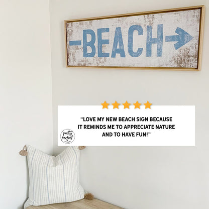 Decorative wall sign with beach text on a wall above a cushioned bench.