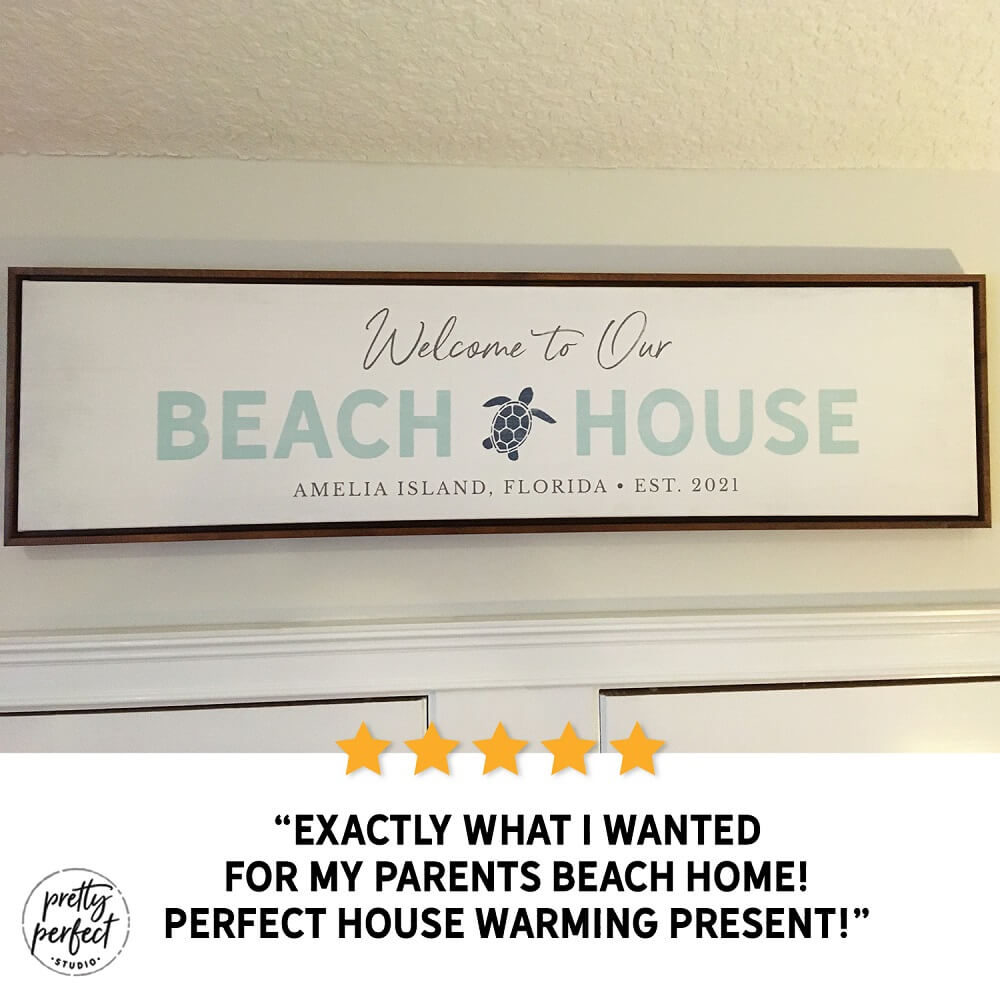 personalized beach house sign with text “Welcome to Our Beach House”, custom coastal wall art with turtle design and location, beach home decor sign for entryway, seaside welcome sign gift for housewarming, customer review photo showing framed beach house sign indoors