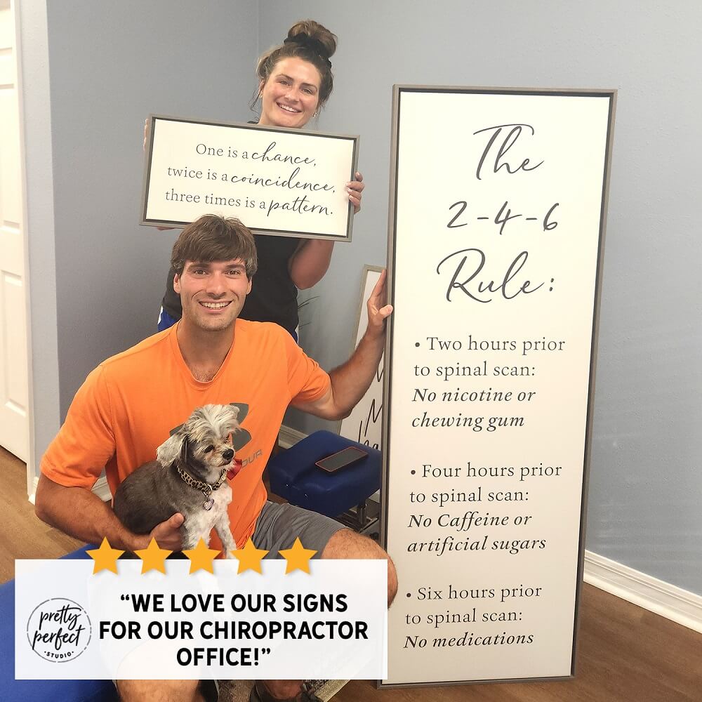 Happy customer holding review signs featuring the 2-4-6 rule, showcasing positive customer testimonial in a chiropractor office with dog