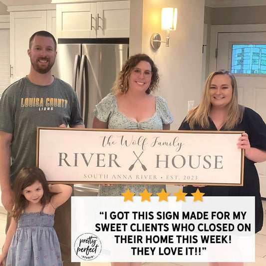 family holding personalized river house canvas sign with custom family name lake and river house wall decor customer testimonial photo