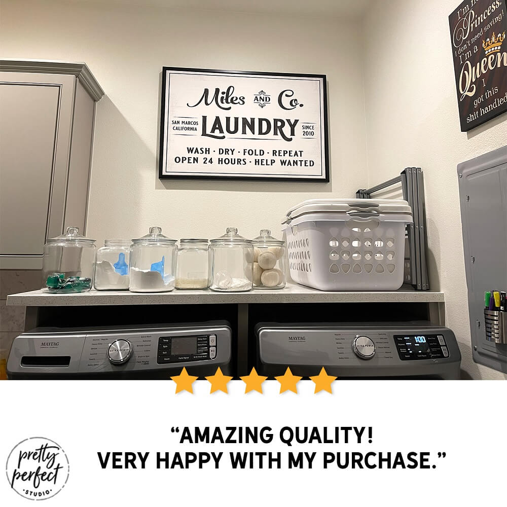 Miles and Co Laundry farmhouse wall sign above washer and dryer, black and white rustic laundry room decor with storage jars and organized shelves