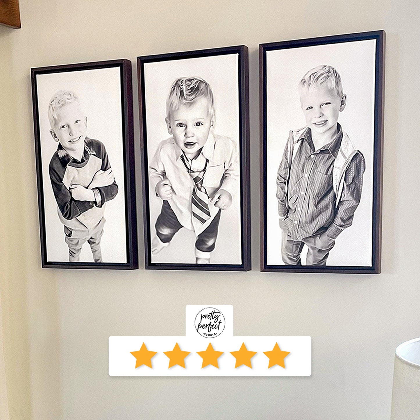 Three framed black and white portraits of young boys on a wall with a five-star rating label for Pretty Perfect Studio.
