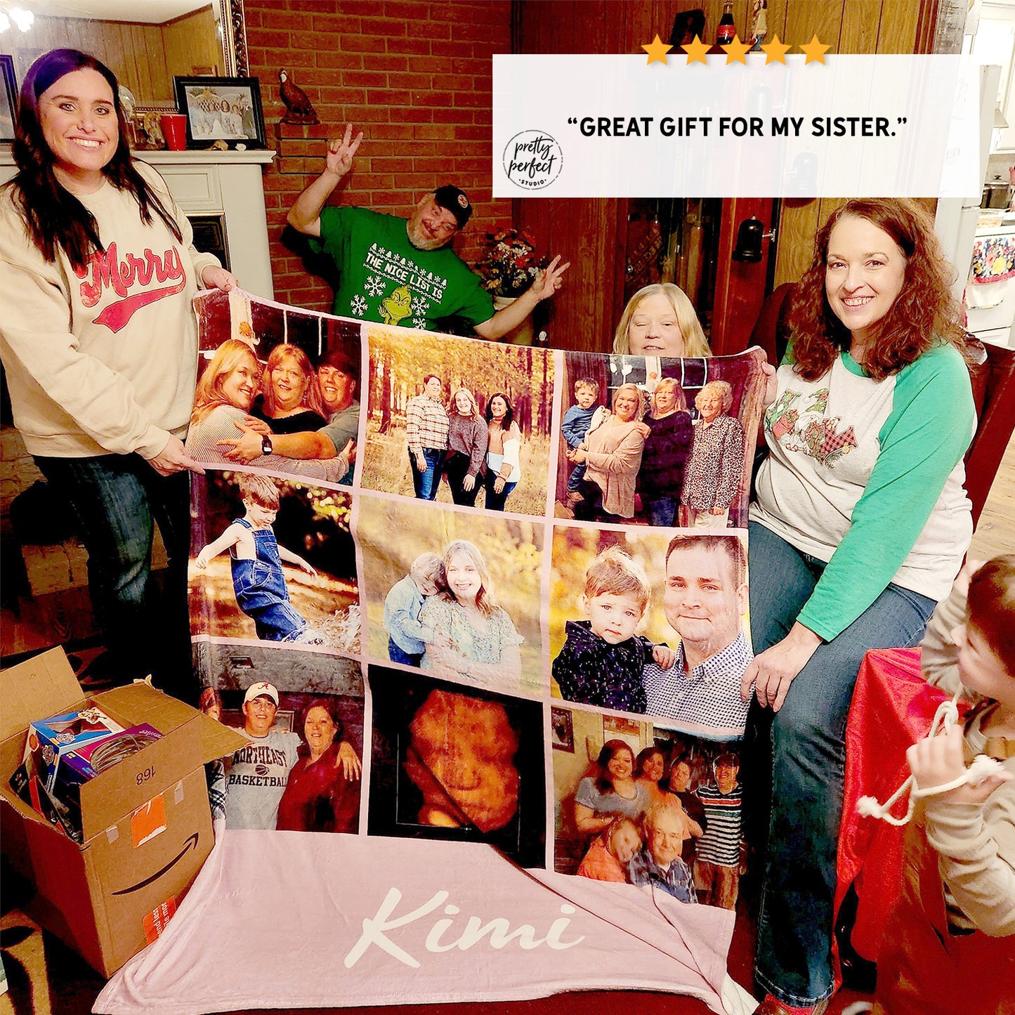 Two women holding a large photo collage blanket with family images.