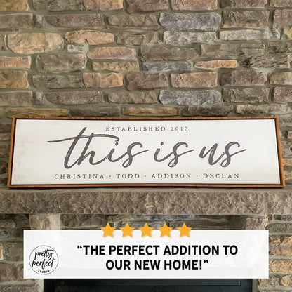 Personalized “This Is Us” family name sign with established date, rustic farmhouse wall decor displayed on stone fireplace mantel