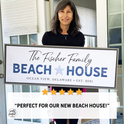 customer holding personalized beach house sign with family name 