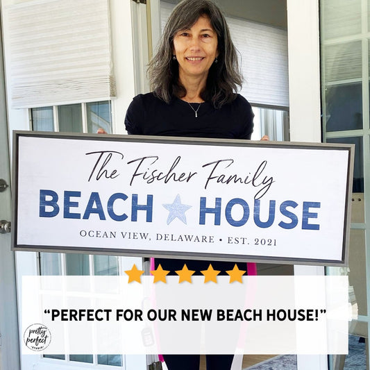 Woman holding custom beach house sign design featuring personalized family name and coastal theme