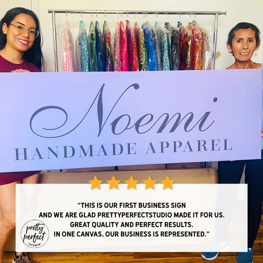 customer photo holding personalized business sign for clothing brand Noemi Handmade Apparel in retail shop