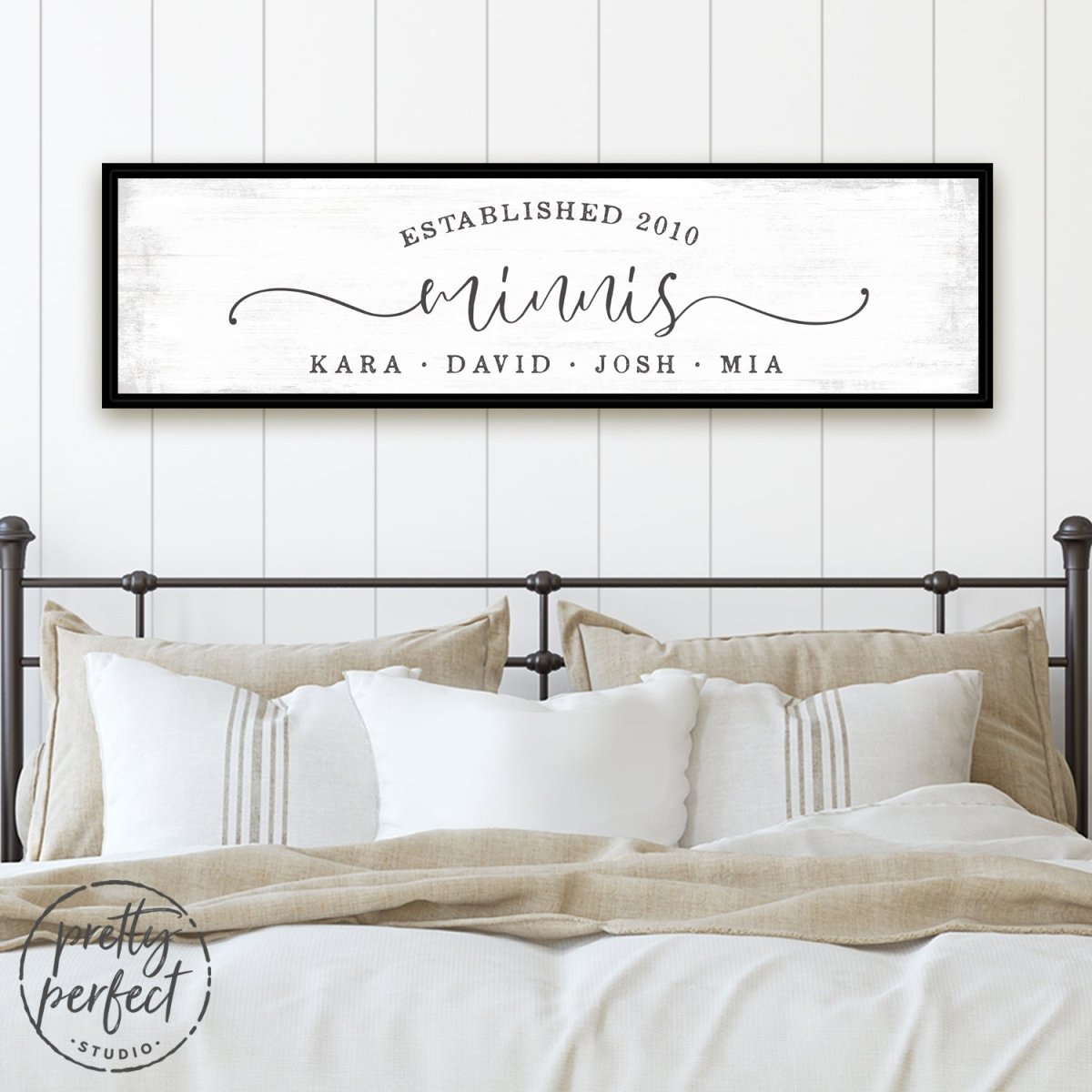 personalized family name wall art with last name, est year, and custom quote on lightly distressed canvas in modern bedroom
