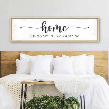personalized home coordinates sign with distressed white background above modern bedroom bed with neutral decor