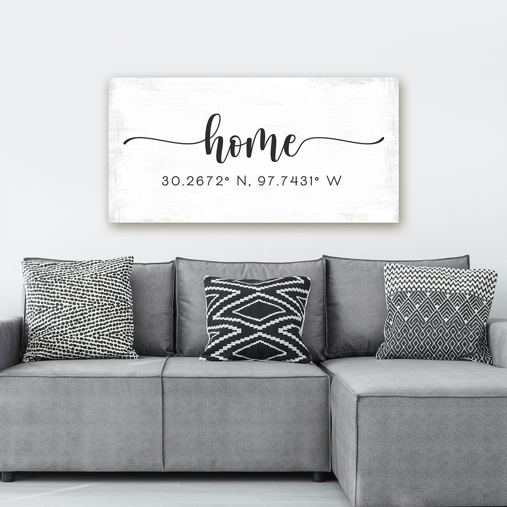 personalized home coordinates canvas wall art with distressed white background above modern gray sectional sofa