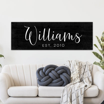 Personalized last name sign Williams est 2010 black wood style custom family name wall decor above couch in living room