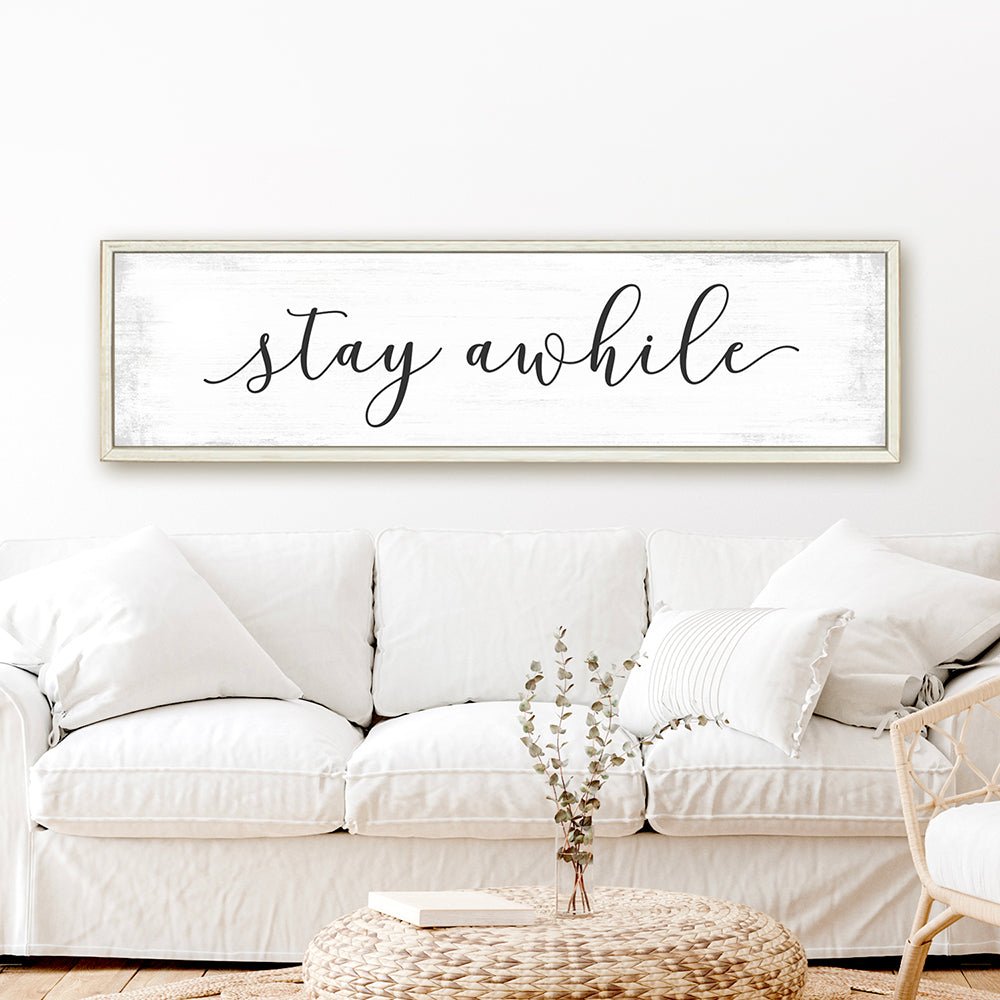 Stay Awhile Canvas Sign Hanging on Wall Above Couch - Pretty Perfect Studio
